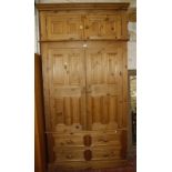 A pine wardrobe in three sections 244cm high x 125cm wide x 59cm deep.