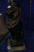 A bronze statue of a seated male lion raised on a marble plinth, 35cm high.