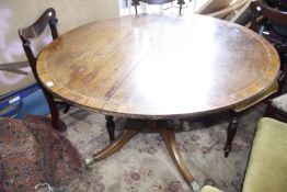 A Regency mahogany and rosewood crossbanded tilt-top dining table with brass stringing, on a bulbous