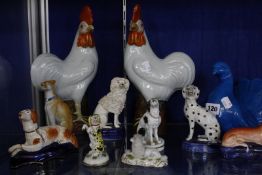 A selection of porcelain and pottery model dogs, a 19th Century Staffordshire model dog, a pair of