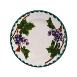 A Wemyss plate, circa 1890, painted with blue and black grapes, impressed  A Wemyss plate, circa