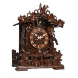 A Black Forest carved wood cuckoo table clock Attributed to Johann Baptist Beha