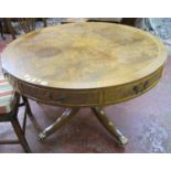 A modern walnut drum table in Regency style, crossbanded on baluster turned stem and four outswept