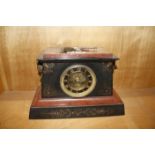 A French black slate and red marble mantel clock with Egyptian hieroglyphics and mask handles, 34.