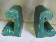 A pair of green leather Harrods retailed book-ends, scrolled shape