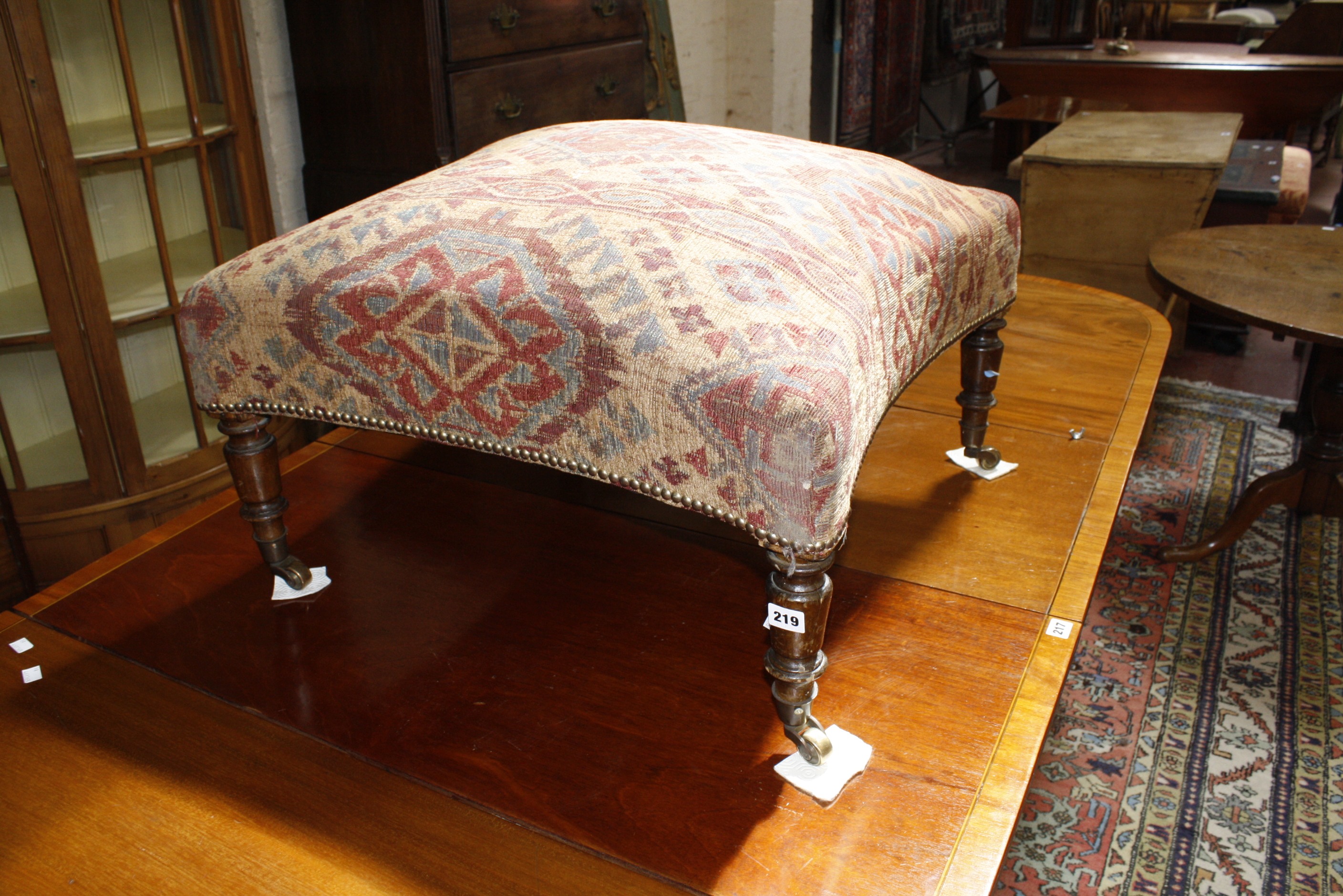 An upholstered centre stool with concave sides 69 x 69cm