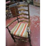 A set of four ladder back chairs with rush seats, including one carver