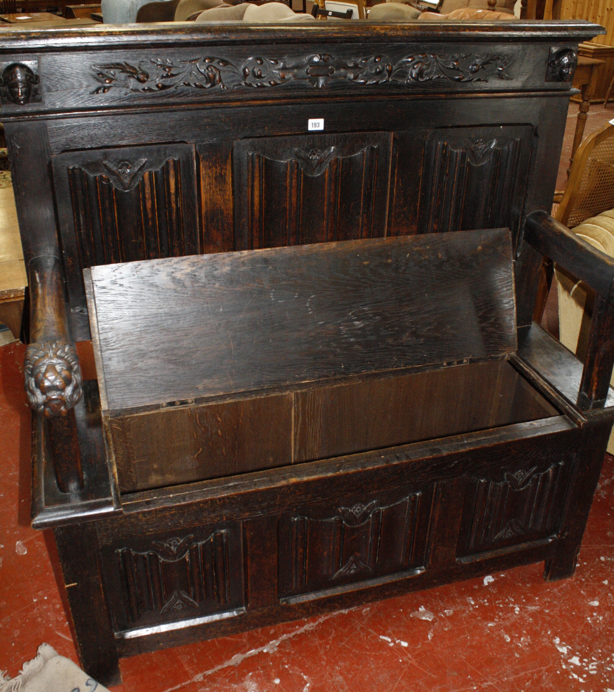 A 19th century oak settle with arms ending in lions head, linen fold back and hinged seat.131cm wide - Image 2 of 2