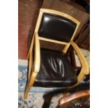 An oak and leather open armchair and an early 20th Century oak desk, with inset writing surface