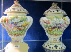 A pair of 20th Century Continental porcelain pot pourri and covers, each having fruit finial and