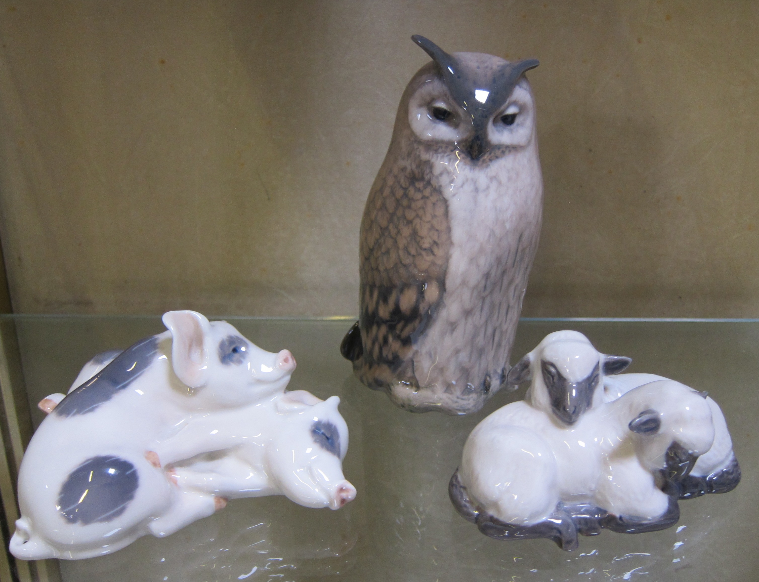 A Royal Copenhagen owl, 15cm high, two lambs sleeping, 5cm high and two pigs resting, 6cm high -3