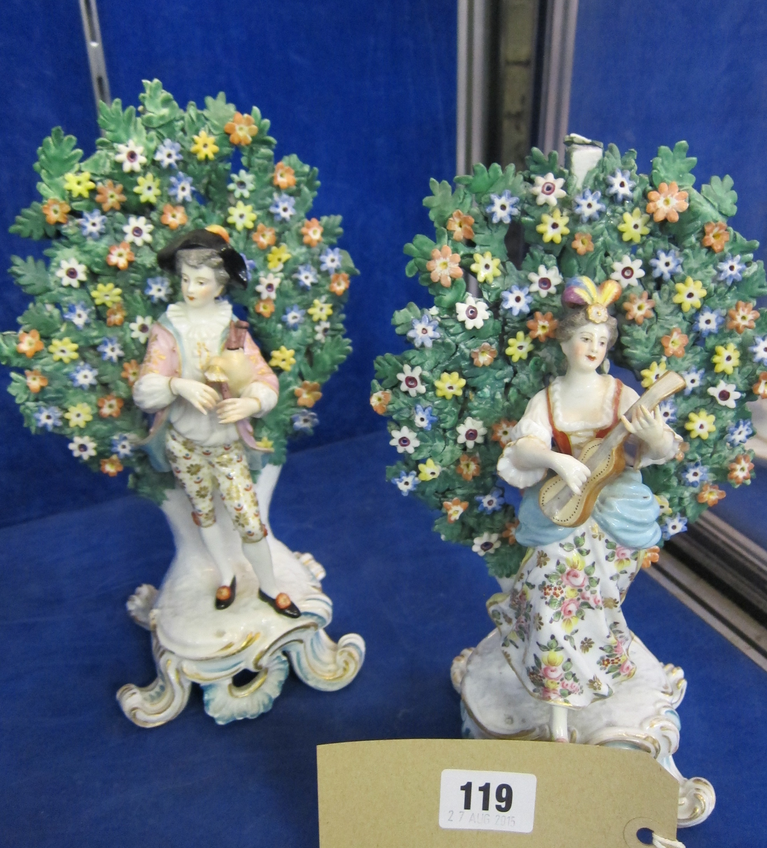 A pair of Derby of musicians, in front a floral bocage, 25cm high