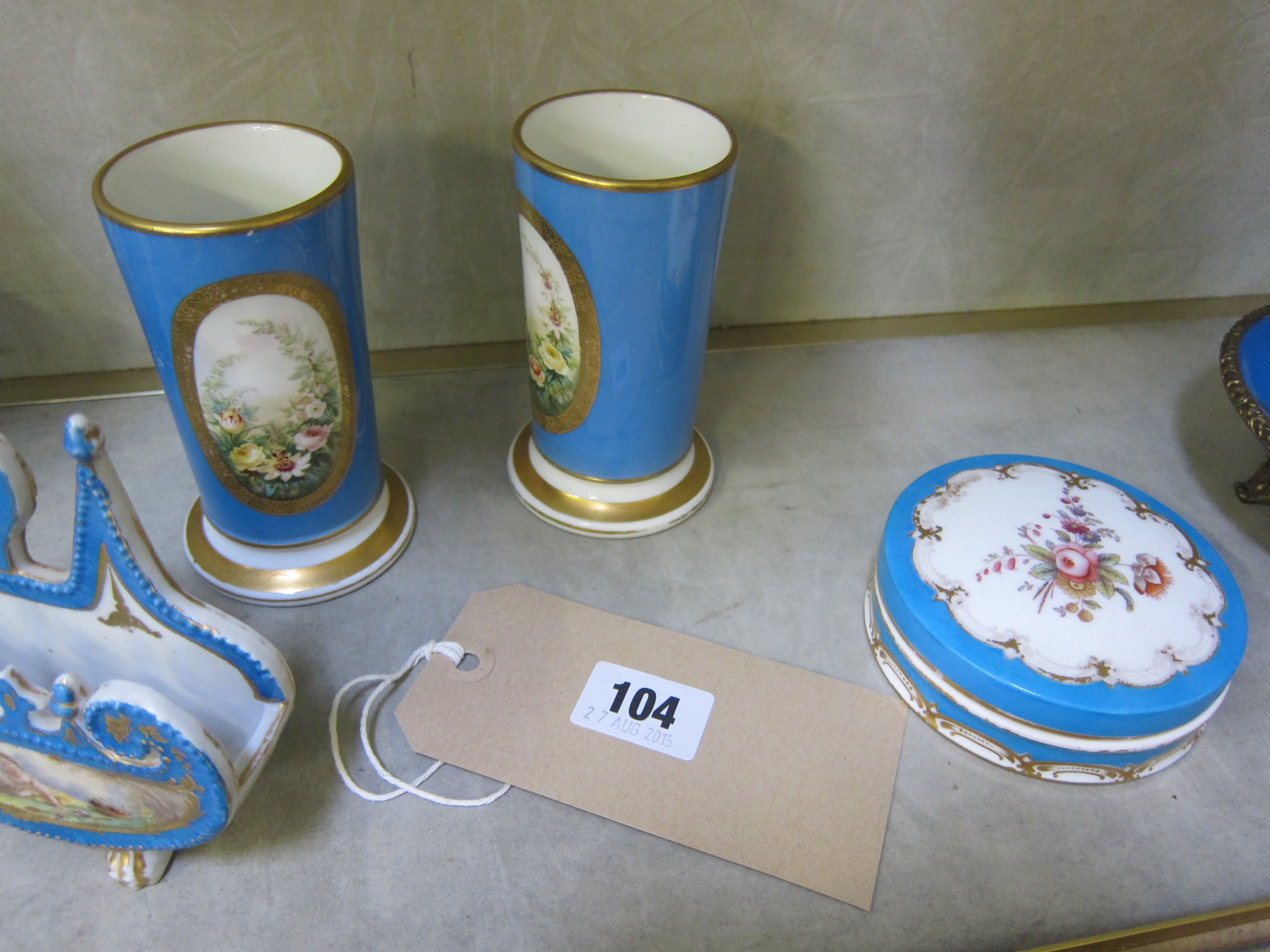 A pair of Sevres style vases painted and gilt with reserves of cherubs, on Bleu Celeste grounds,