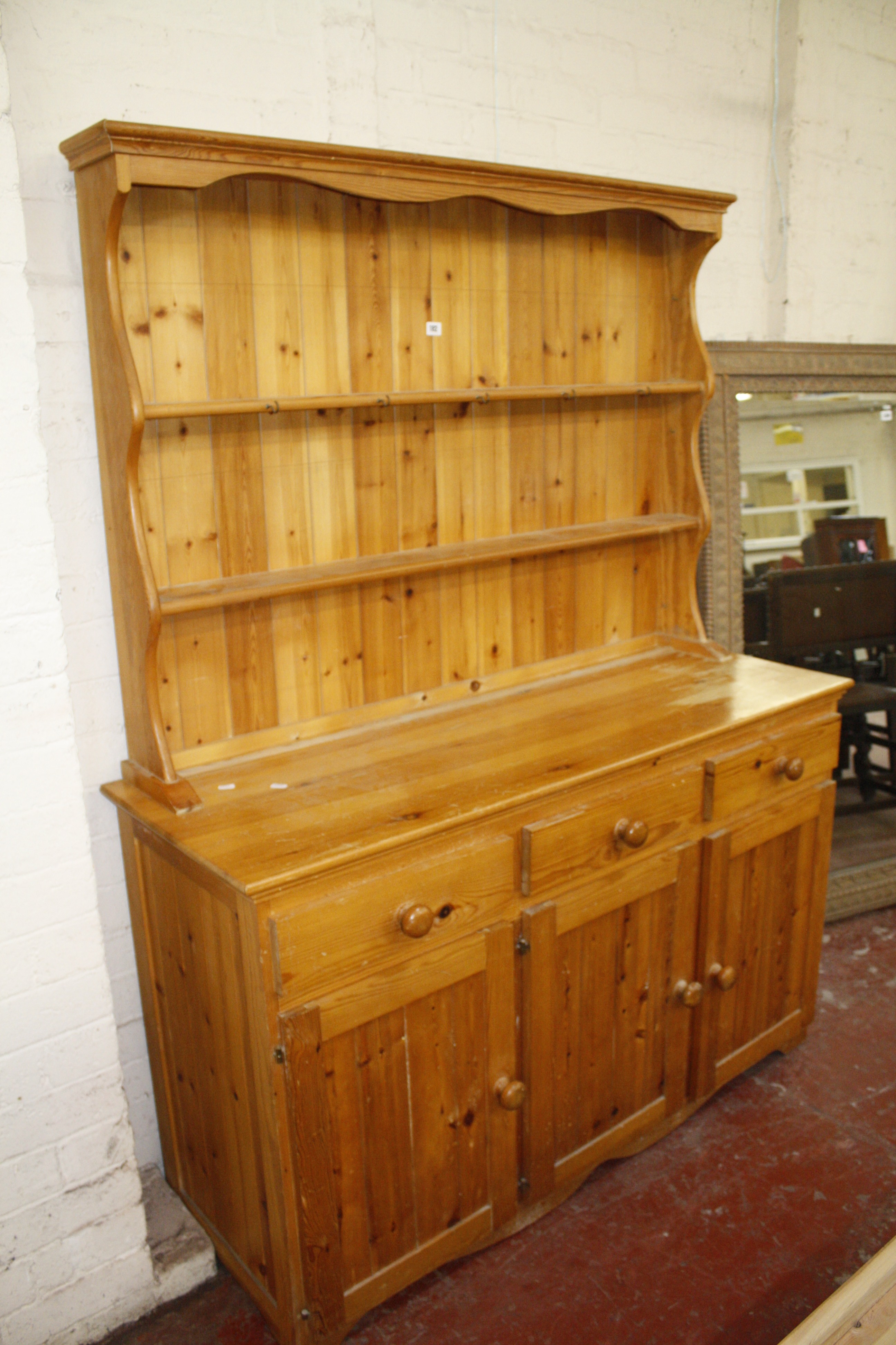 A pine dresser with enclose plate rack, three frieze drawers and cupboards below.180cm high x