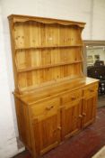 A pine dresser with enclose plate rack, three frieze drawers and cupboards below.180cm high x