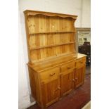 A pine dresser with enclose plate rack, three frieze drawers and cupboards below.180cm high x