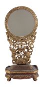 A Chinese red and gilt carbed wood table mirror on a stand, 66cm high  A Chinese red and gilt carbed