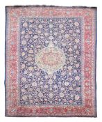 A Kirman carpet, the central medallion within a field of meandering foliage...  A Kirman carpet,