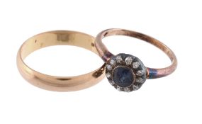 A sapphire and diamond ring,   the central circular shaped sapphire collet set within a surround of