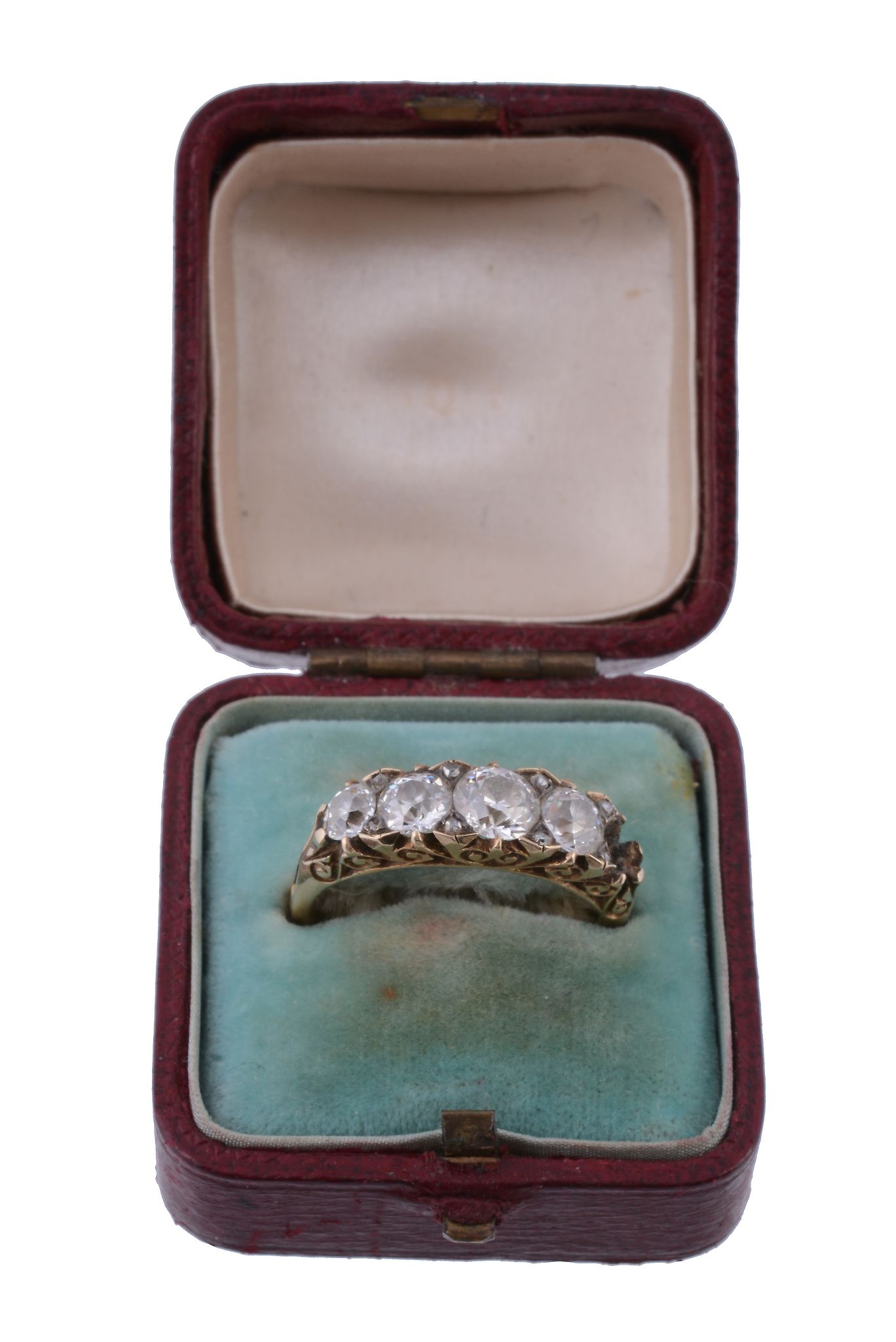 A diamond ring,   the four old brilliant cut diamonds claw set within a pierced scroll surround