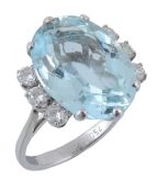 An aquamarine and diamond ring,   the central oval shaped aquamarine in a six claw setting, the