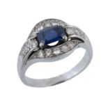 A sapphire and diamond dress ring,   the step cut sapphire with canted corners to a pierced diamond