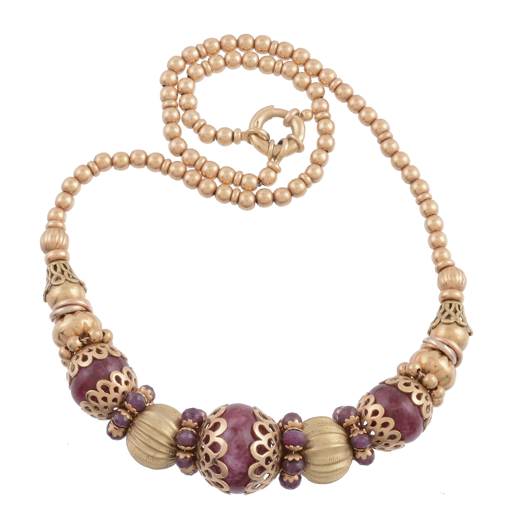 A ruby bead necklace,   the central polished ruby bead in a pierced scallop setting between further