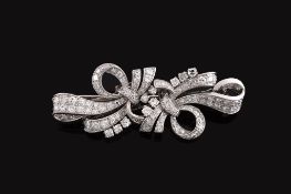 A diamond double clip brooch,   the scrolling ribbon bow set throughout with eight cut diamonds,