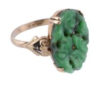 A jade panel ring,   the carved oval jade panel claw set between scrolled shoulders, stamped 9K,