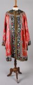 A late 19th century Chinese coral silk robe, embroidered throughout with flowers, with a black