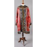 A late 19th century Chinese coral silk robe, embroidered throughout with flowers, with a black