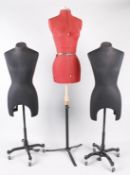 Two black fabric covered costume display mannequins on wheels; together with a red adjustable