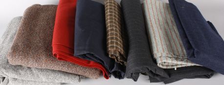 A suitcase of vintage tweed and dressmaking fabrics, including: a bolt of charcoal grey pinstripe