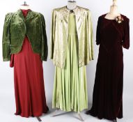 A 1950s lame jacket with an emerald coloured lining, a 1930s velvet claret coloured evening gown,