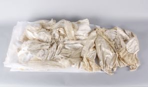 An early 20th century ivory silk wedding gown, with cream net sleeves gathered at the elbows, tiny
