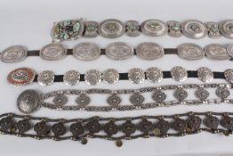 Five metal belts, comprising: a chunky sterling silver belt made up of silver ovals and bow-