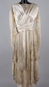 A 1920s wedding dress by Charles Lee & Son of Wigmore St. London, cream satin overlaid with a