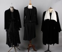 A 1920s black velvet evening coat trimmed with white fur, a 1930s black georgette and lace dress,