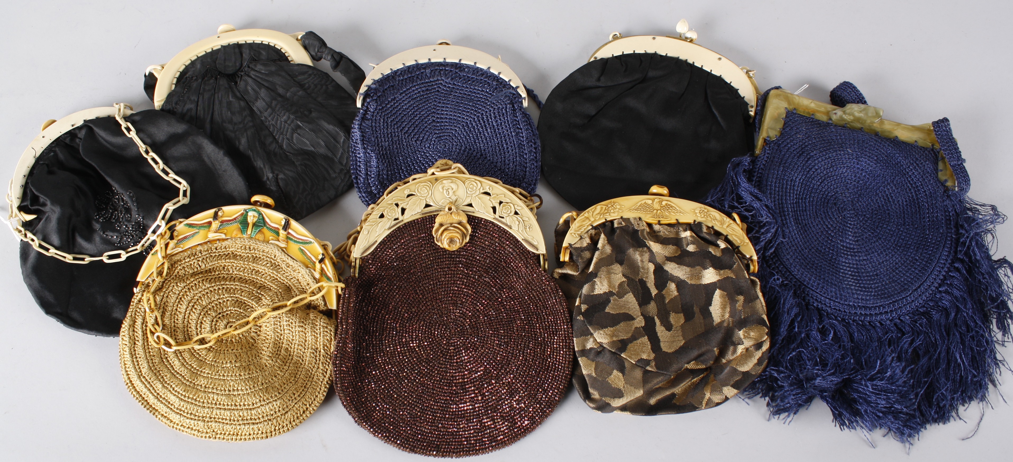 A collection of early 20th century woven and fabric evening bags, with curved handles made from