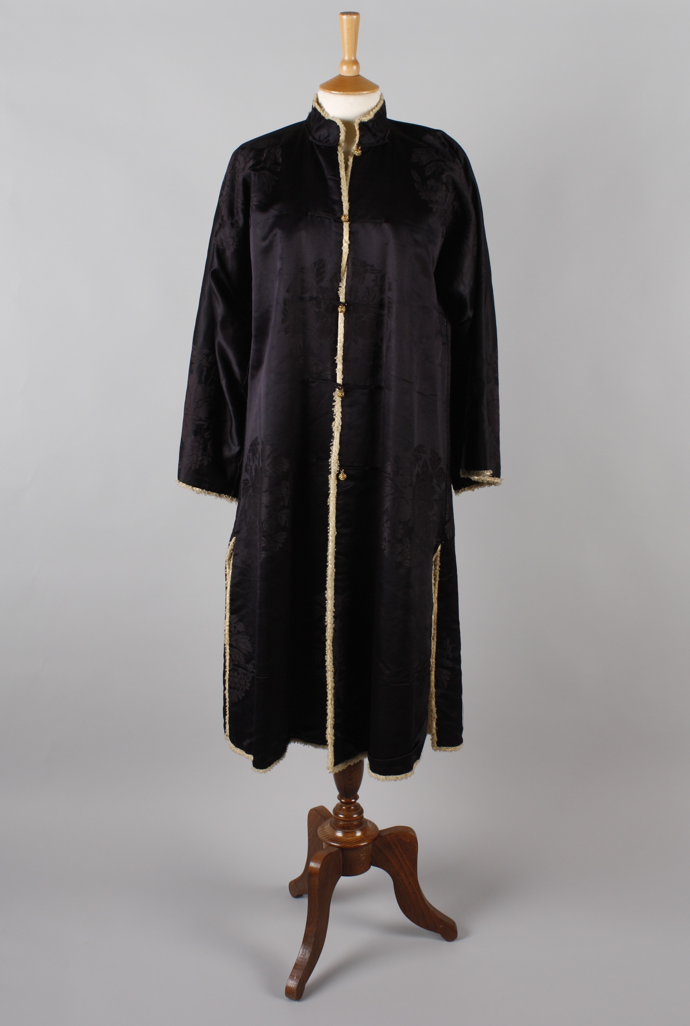 A Chinese midnight blue silk winter coat, lined with sheepskin, having a Mandarin collar, side vents