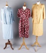 Six maternity outfits from the 1930s to the early 1950s, including: a blue and white spotted