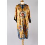 A Chinese yellow silk coat with maroon lining, the embroidered decoration of roundels worked in