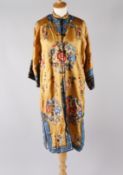 A Chinese yellow silk coat with maroon lining, the embroidered decoration of roundels worked in