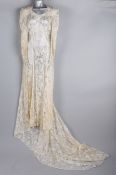 A 1930s tulle and beaded wedding gown; together with a 1940s cream lace wedding dress and slip, a