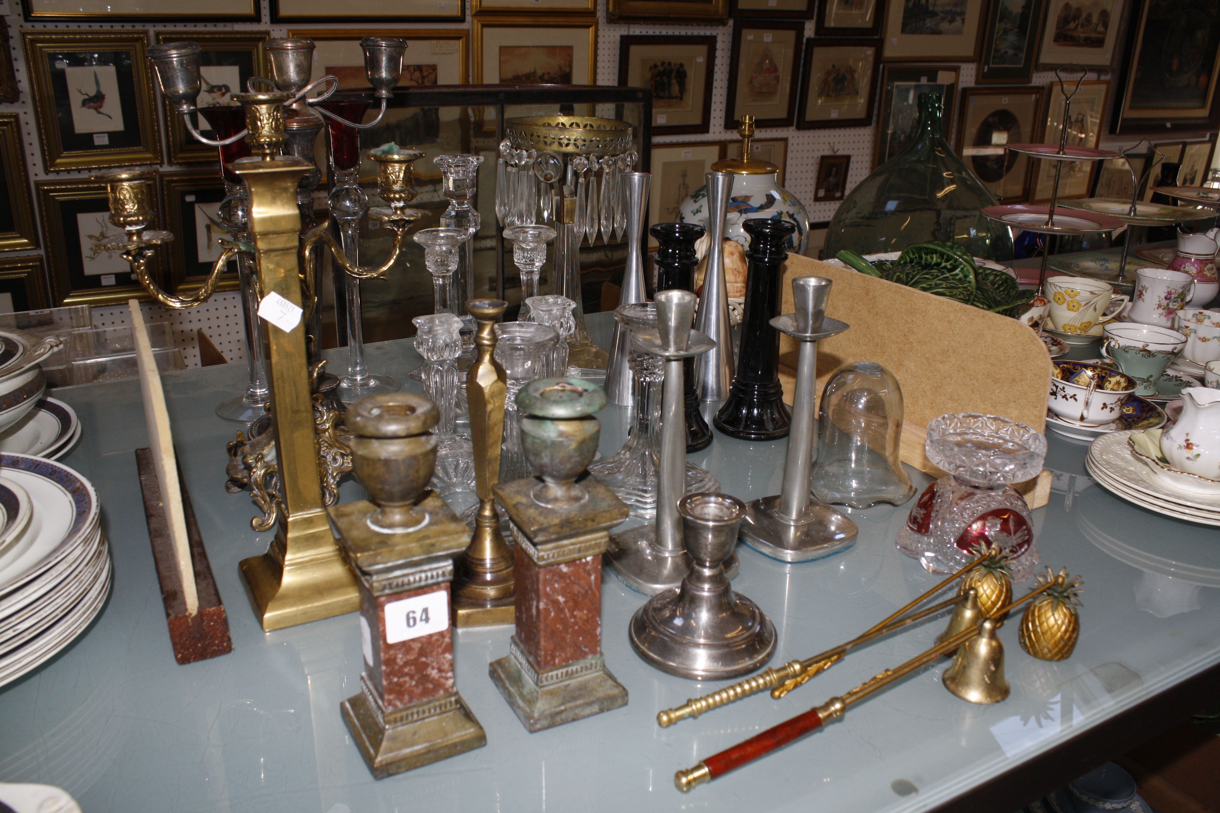 A selection of glass and metal candleholders, to include a pair of brass urns on marble stands, a