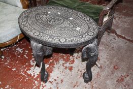An Indian carved hardwood oval table on elephant head style legs 76cm