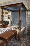 A four poster bed with Georgian posts with reeded decoration, together with the drapes, 154cm wide x