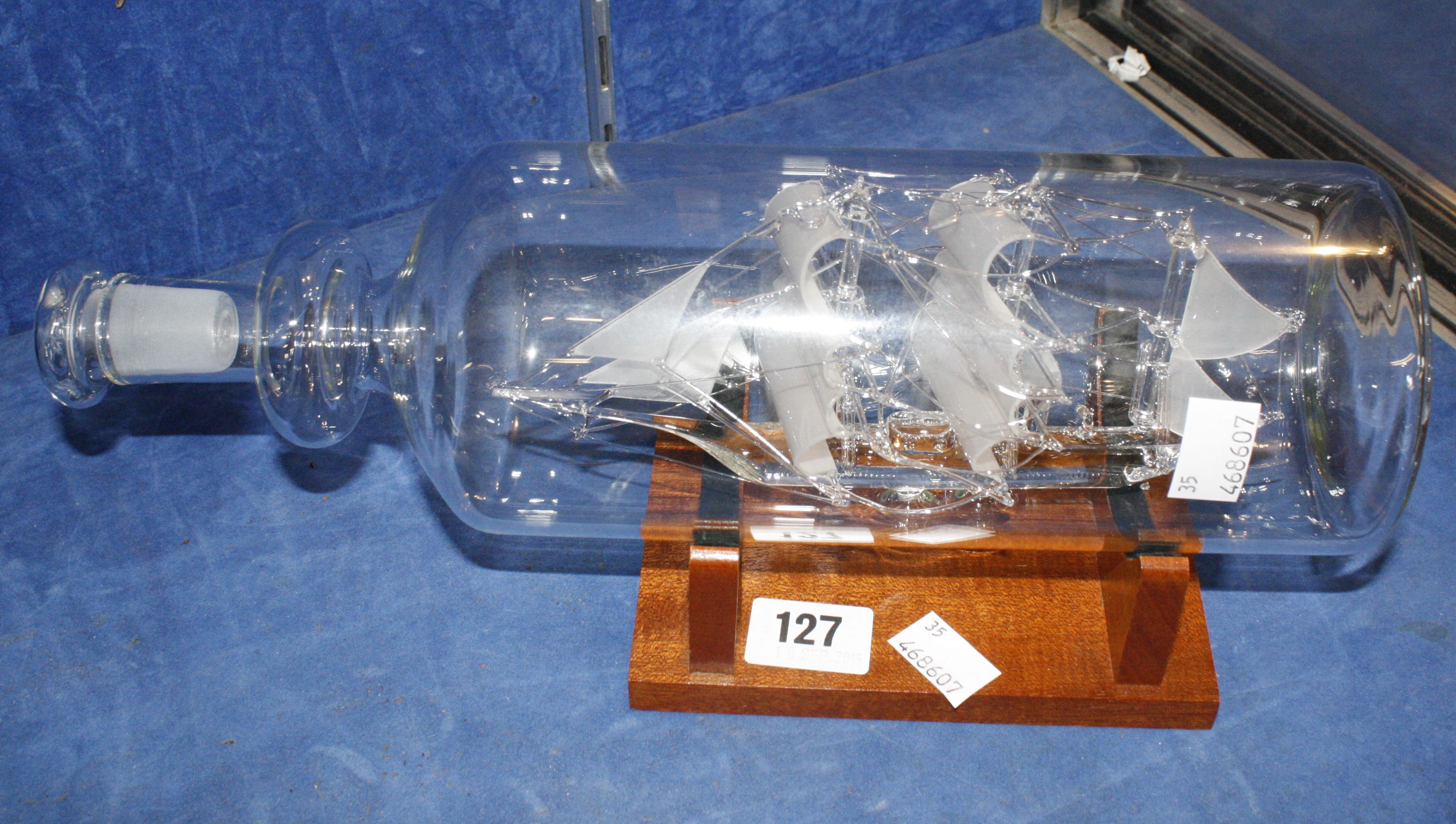 A Glass ship in a bottle by Lichfield glass, on wooden base