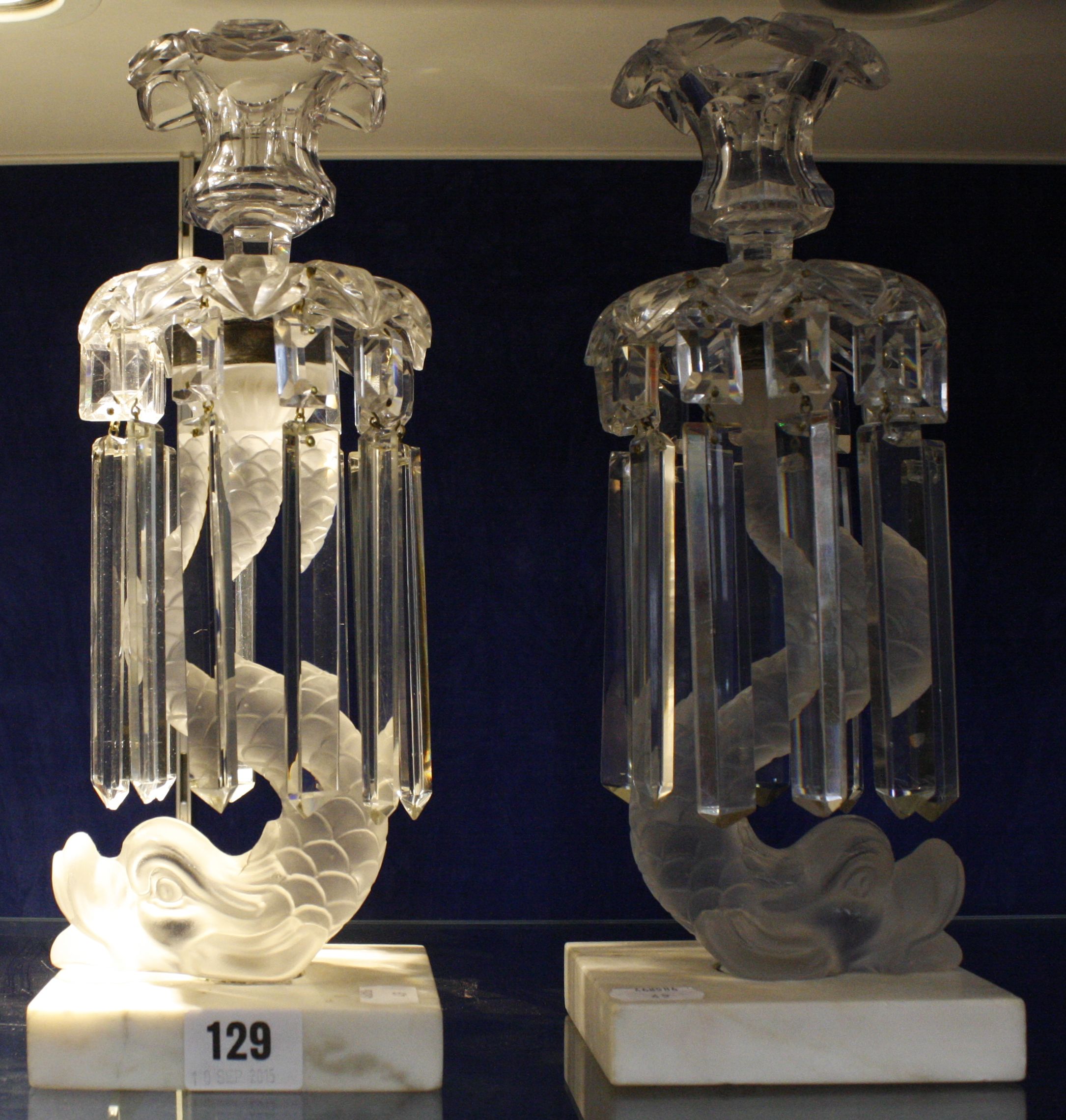 A pair of clear and frosted glass table lustres, with dolphin columns and marble bases, 31cm high