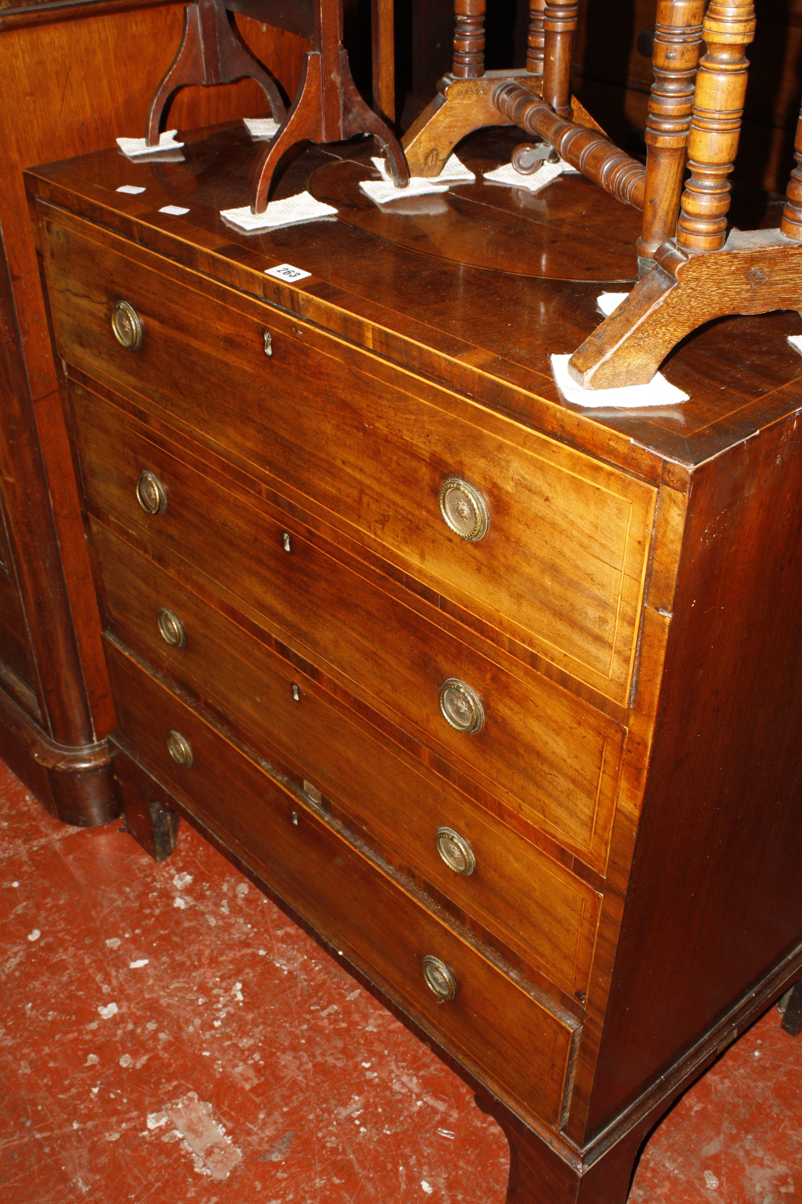 A 19th Century mahogany chest with inlaid oval top and four long drawers on bracket feet 80cm wide